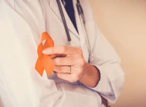Doctor holding orange ribbon, Leukemia cancer awareness and Multiple sclerosis and ADHD , COPD awareness, world kidney day